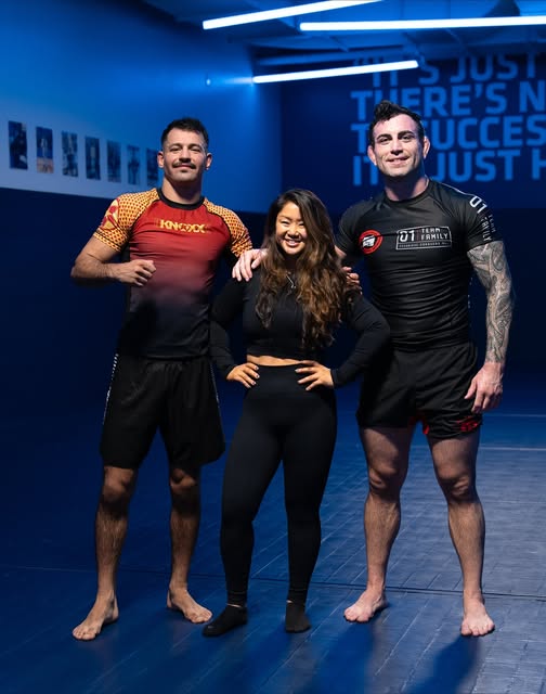 Three martial artists together on the mats